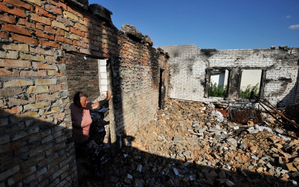 67-letnia Olga patrzy na swój zniszczony dom podczas bombardowania wsi Moshchon w obwodzie kijowskim 28 lipca 2022 r. podczas inwazji rosyjskiej na Ukrainę.