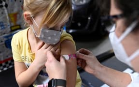 Six-year-old Hanna (left) receives a plaster after having been inoculated with the Pfizer BioNTech Covid-19 vaccine for children at a vaccination centre in Iserlohn, western Germany, on 5 January, 2022.