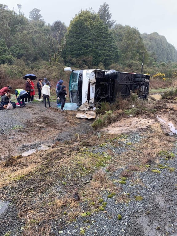 People support one another at the bus crash near Rotorua that has killed at least five people.