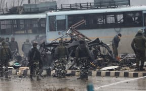 Indian security forces inspect the remains of a vehicle following an attack on a paramilitary Central Reserve Police Force (CRPF) convoy that killed at least 40 troopers and injured several others near Awantipur town in the Lethpora area of Kashmir about 30km south of Srinagar on February 14, 2019.