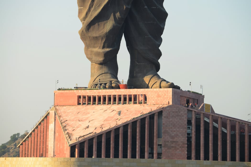 Indian construction workers are seen at the plimth structure the "Statue Of Unity".