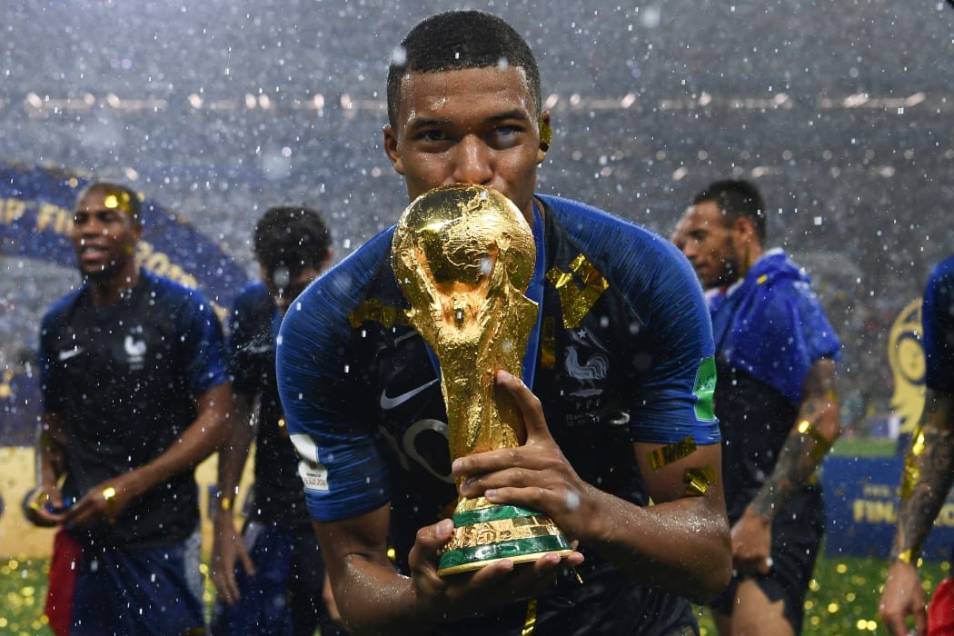 Kylian Mbappe kisses the World Cup trophy