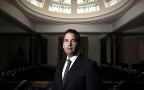 Simon Bridges stands in the atrium of the National Party offices.