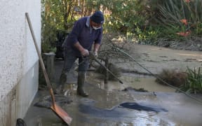 Whanganui resident Jimmy helps clear away mud from the back of his neighbour's property.