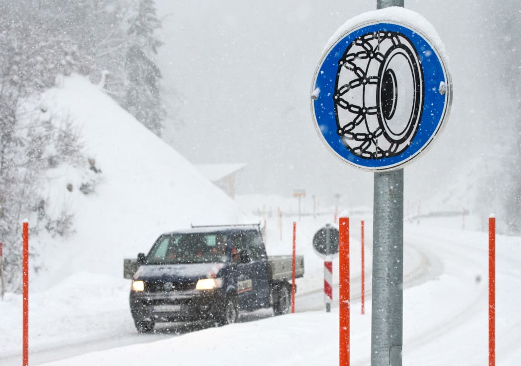 05 January 2019, Bavaria, Bolsterlang: If there is heavy snowfall in the Allgäu, a sign indicates that snow chains must be used to reach the Riedberg Pass. Photo: Oliver Willikonsky/dpa
