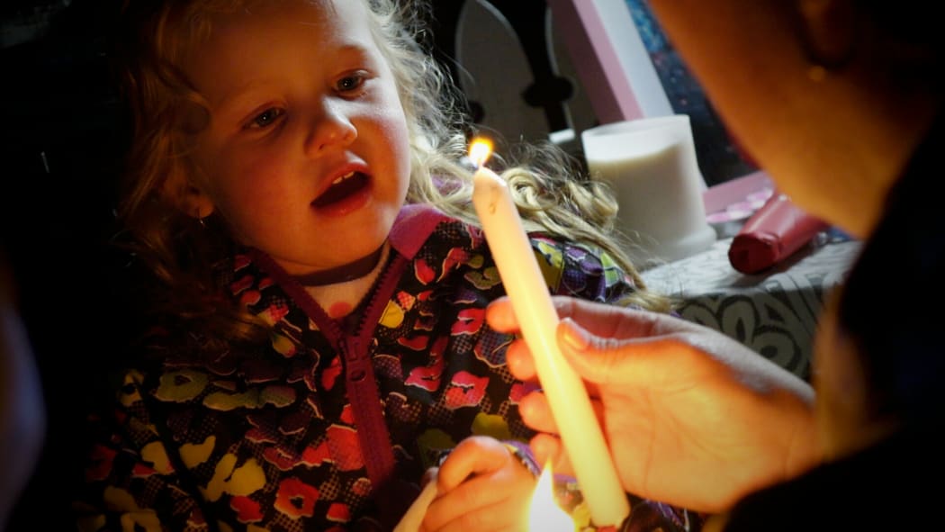 A child attends the candlelit vigil in memory of four-year-old Maggie Renee Watson.