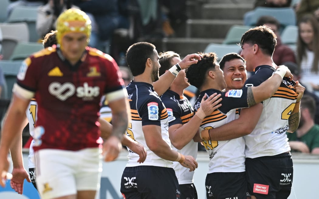 Darcy Swain of the Brumbies celebrates with team mates after scoring a try against the Highlanders.