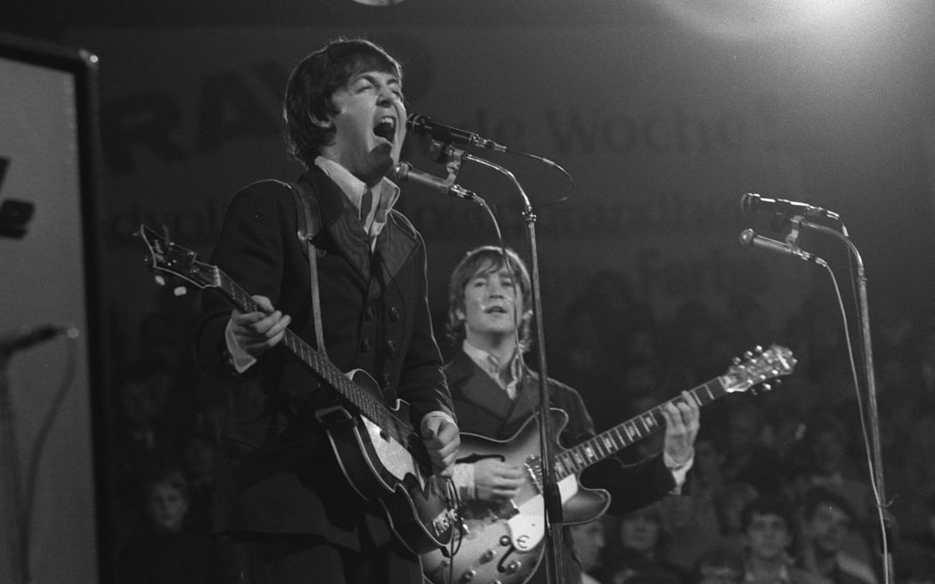 ARCHIVE PHOTO: Musician Paul McCARTNEY turns 80 on June 18, 2022, Paul McCARTNEY (front) sings with all his might into a microphone, behind is John LENNON , half-length, playing guitar; Beatles singer musician England Liverpool GBR music beat music pop music concert The Beatles in the Circus Krone in Munich, on June 24th, 1966; black and white shot; (Photo by SVEN SIMON / SVEN SIMON / dpa Picture-Alliance via AFP)