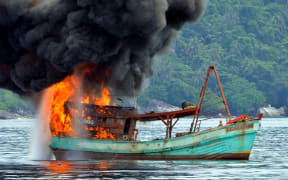 This picture shows a Vietnamese fishing boat in flames after Indonesian Navy officers blew up the vessel due to illegal fishing activities in the remote Anambas Islands.