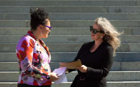 MP Louisa Wall receives the petition from Gender Justice Collective's Angela Meyer in front of Parliament this afternoon.