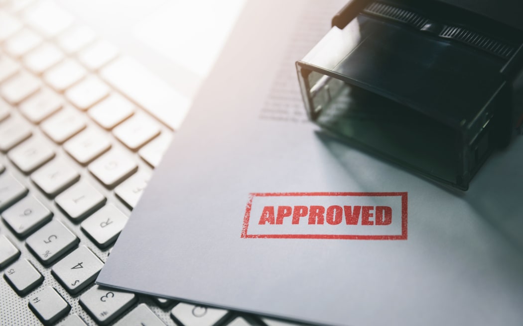 document with approved stamp on computer keyboard