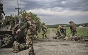 Ukrainian servicemen help comrades near the frontline in Donbas on May 22.