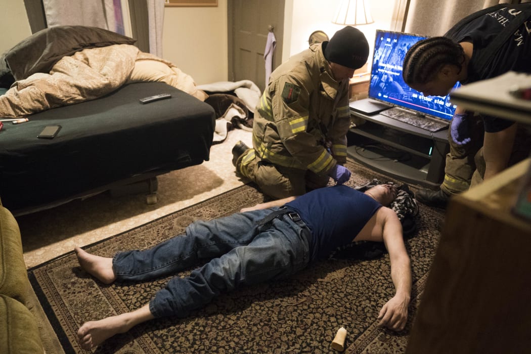 Firefighter Jim Terrero assesses the condition of a 35-year-old man who had overdosed on heroin March 28, 2018 in Manchester, New Hampshire.