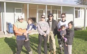 Te Tuhi Walker (left), holding Jaxson-Hayze Walker, and Levi Williams (right), holding Jazmyne Walker with housing advocates Leah Jacobs, Dee Puhipuhi and Hope Jones outside the empty Kāinga Ora home they “broke into” in a desperate effort to find a home. The house, however, is a possible health and safety fix. Kāinga Ora has found a temporary home for the family.
