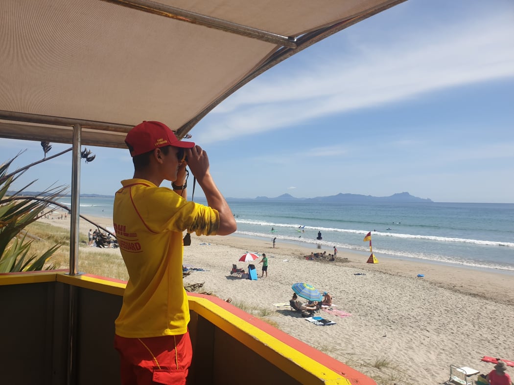 SLSNZ volunteer Surf Lifeguard with binoculars