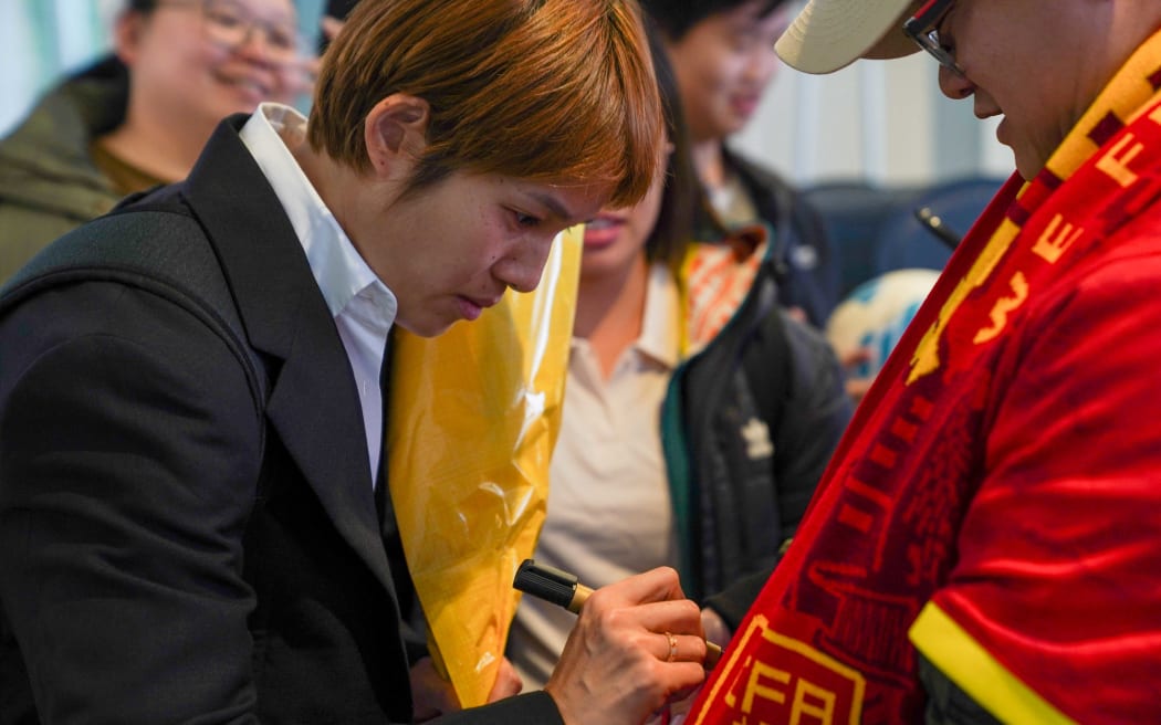 China's football player Zhang Xin signs autographs for fans at the airport in Adelaide, after their arrival for the 2023 FIFA Women's World Cup.