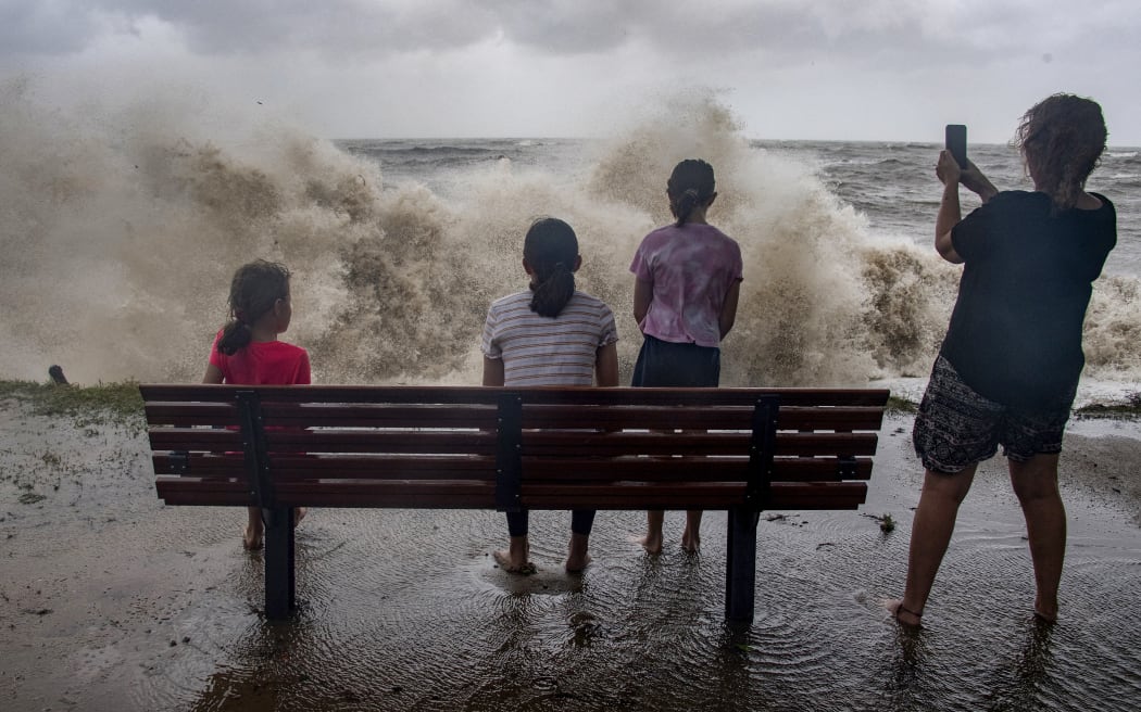 Una familia observa el paso de la tormenta sobre el Mar del Coral en la playa de Holloways mientras el ciclón Jasper se acerca a Cairns, en el extremo norte de Queensland, el 13 de diciembre de 2023. Un ciclón tropical estaba ganando fuerza a medida que avanzaba hacia el noreste de Queensland, Australia, el 13 de diciembre, y las autoridades advirtieron 