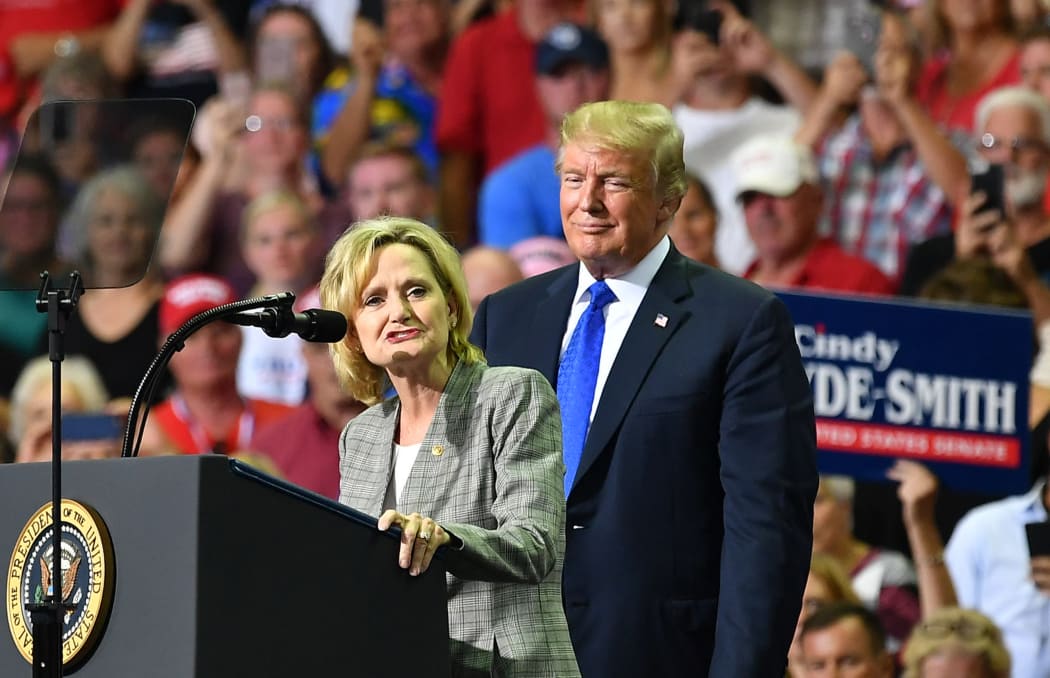 Senator Cindy Hyde-Smith (L) stands on stage with President Donald Trump at a rally in Southaven, Mississippi. 3 October