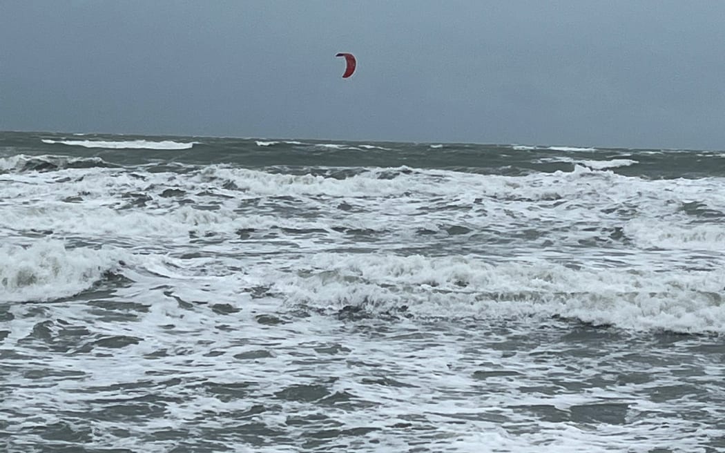 Strong winds and a high tide have washed away part of Orewa Beach in north Auckland. One kite surfer is out in the heavy swell.