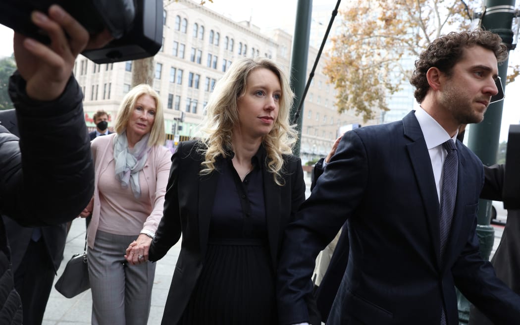 SAN JOSE, CALIFORNIA - NOVEMBER 18: Former Theranos CEO Elizabeth Holmes (C) arrives at federal court with her partner Billy Evans (R) and mother Noel Holmes on November 18, 2022 in San Jose, California. Holmes appeared in federal court for sentencing after being convicted of four counts of fraud for allegedly engaging in a multimillion-dollar scheme to defraud investors in her company Theranos, which offered blood testing lab services.   Justin Sullivan/Getty Images/AFP (Photo by JUSTIN SULLIVAN / GETTY IMAGES NORTH AMERICA / Getty Images via AFP)