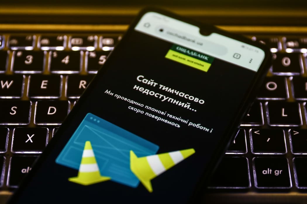 An alert on Oschadbank website is displayed on a mobile phone on February 15, 2022 as the Ukrainian government accused Russia of being behind a cyberattack on dozens of official websites.