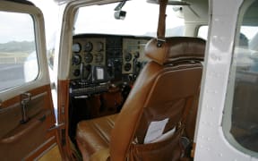 small cesna airplane with open door. Looking into interior and instruments. Instruments out of focus.