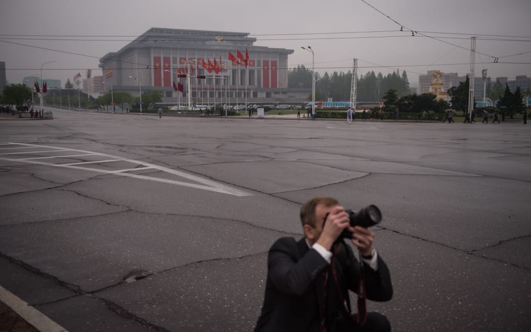 A foreign press photographer in front of the April 25 palace.