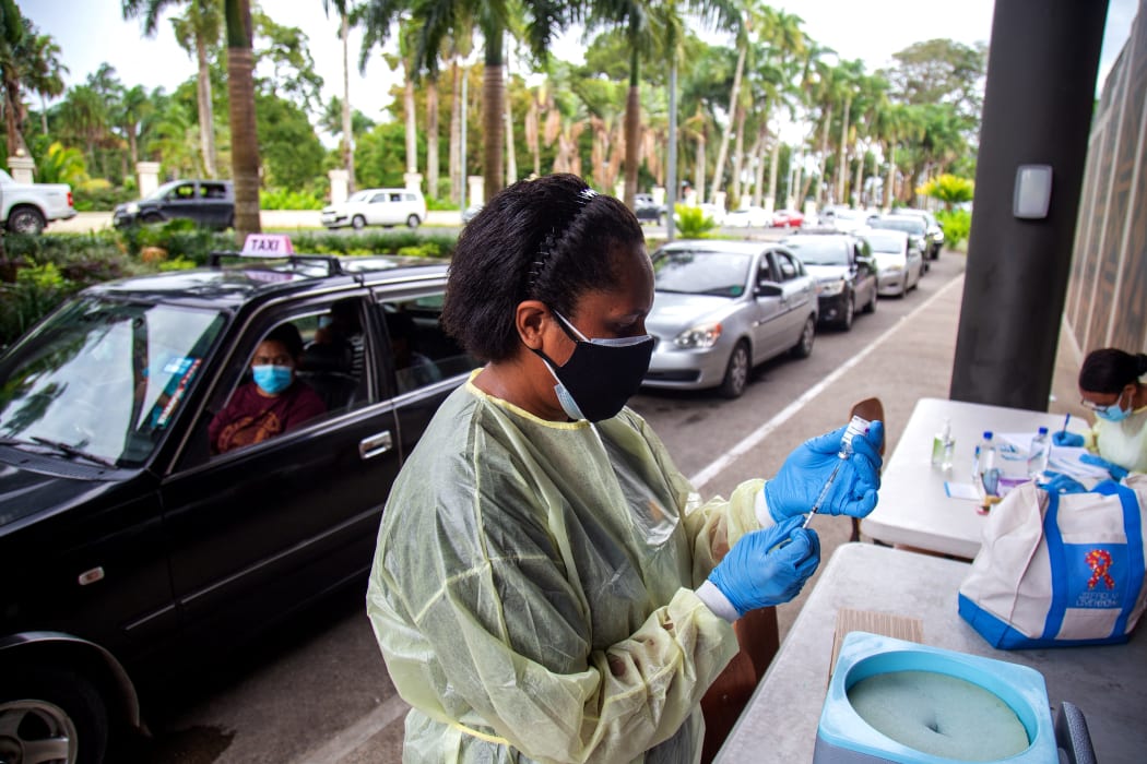 A health worker prepares a dose of the AstraZeneca vaccine for a resident at a drive-through vaccination centre in Suva.
