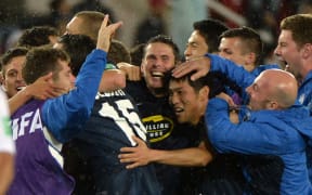 Auckland City's players celebrate with coaching staff after defeating ES Setif during their 2014 FIFA Club World Cup quarter-final.