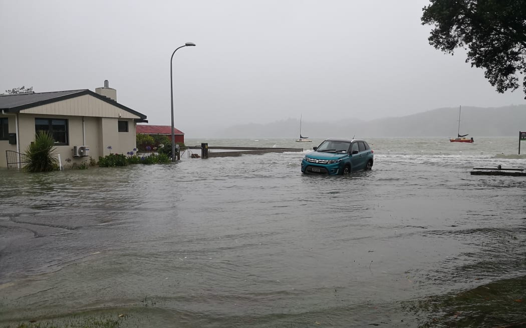 A car gets caught in flooding in Raglan.