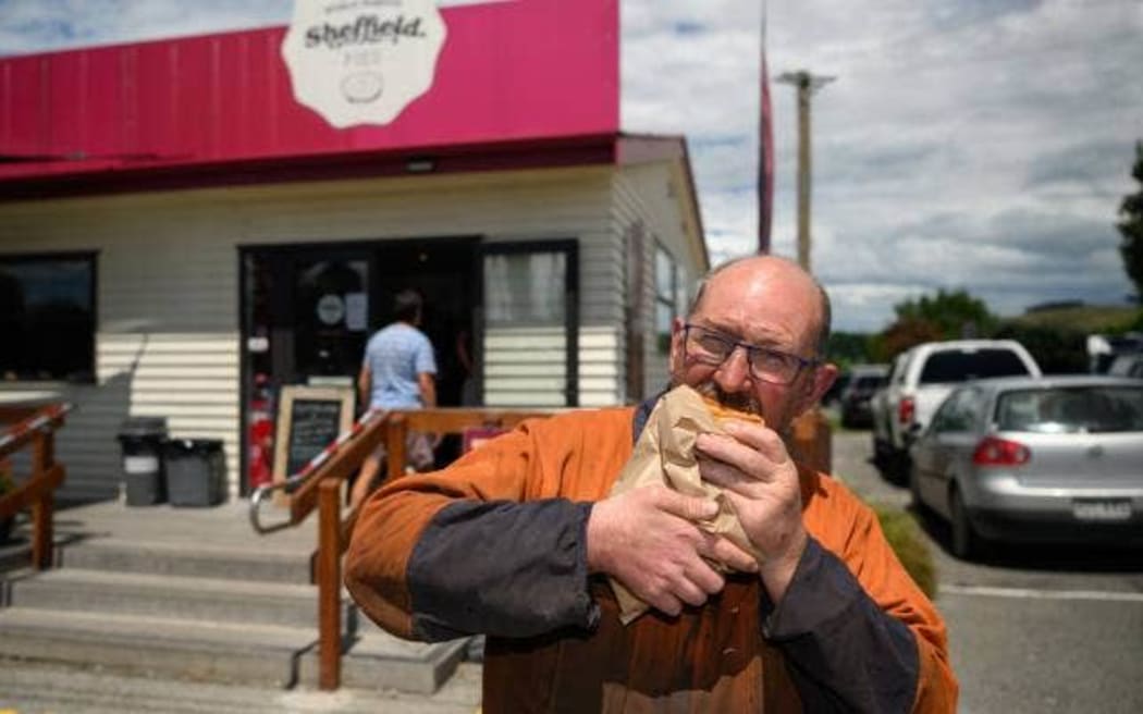 Horolata patron Richard Broughton enjoys a pie in front of Sheffield Pie's flagship store.