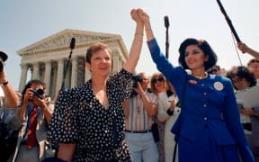 Norma McCorvey, Jane Roe in the 1973 court case (left) and attorney Gloria Allred (right) hold hands as they leave the Supreme Court building in Washington on April 26, 1989, after sitting in court listening to arguments in a Missouri abortion case.