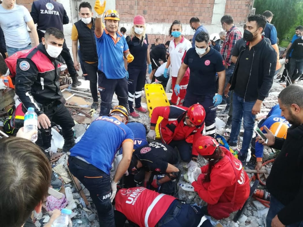 Rescuers search for survivors at a collapsed building after a powerful earthquake struck Turkey's western coast and parts of Greece, in Izmir, on October 30, 2020.