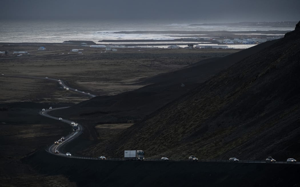 Esta foto, tomada el 13 de noviembre de 2023, muestra vehículos saliendo de la ciudad de Grindavik en el suroeste de Islandia durante la evacuación después de los terremotos.  La ciudad de Grindavik, en el suroeste del país -donde viven unas 4.000 personas- fue evacuada en las primeras horas del 11 de noviembre, después de que el movimiento del magma bajo la corteza terrestre provocara cientos de terremotos, que los expertos advirtieron que podrían ser un precursor de una erupción volcanica.