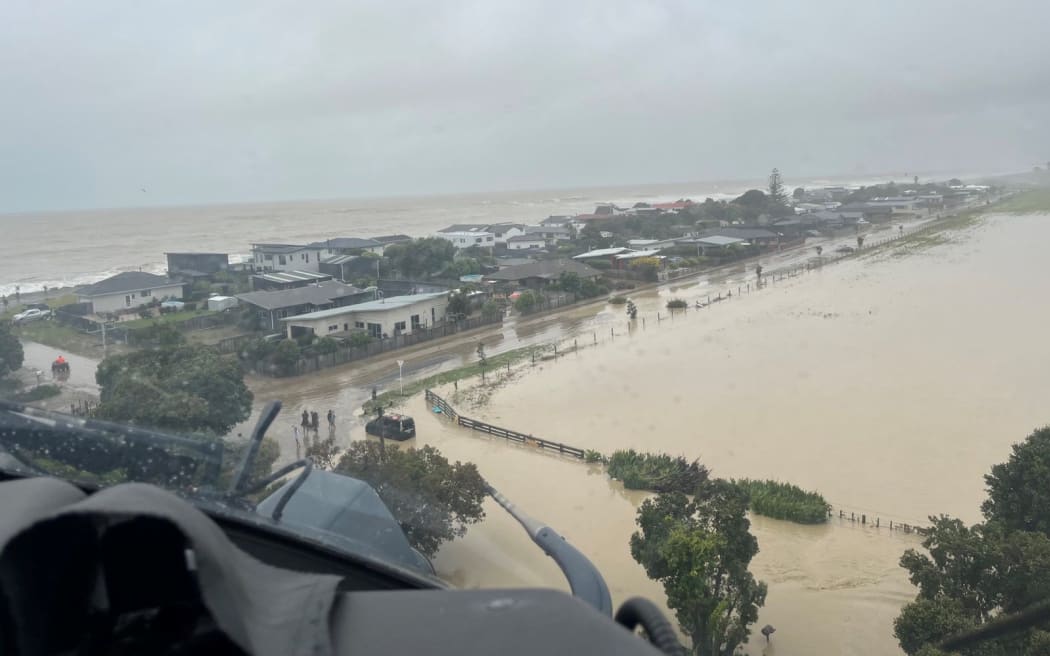 An NH90 helicopter and crew recover people from the rooftops of their homes in Esk Valley, Napier.