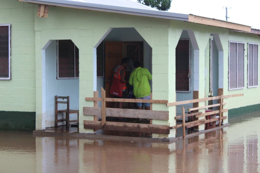 Red Cross workers go door to door in Samoa to check on residents in the wake of Cyclone Gita
