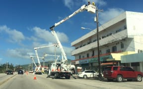 A utility crew works hard on restoring power lines on Saipan