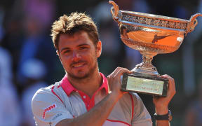 The Swiss tennis player Stan Wawrinka holds aloft the 2015 French Open trophy.
