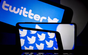 The logo of "twitter" is displayed on a smartphone and a screen in Ankara, Turkey on July 20, 2021.