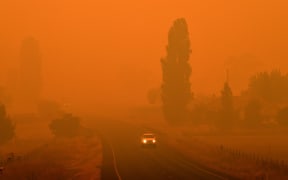 Residents commute on a road through thick smoke from bushfires in Bemboka, in Australia's New South Wales state on Sunday 5 January, 2020.