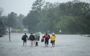 Volunteers from the Civilian Crisis Response Team help people to higher ground after rescuing them from their flooded homes during Hurricane Florence in James City, North Carolina.