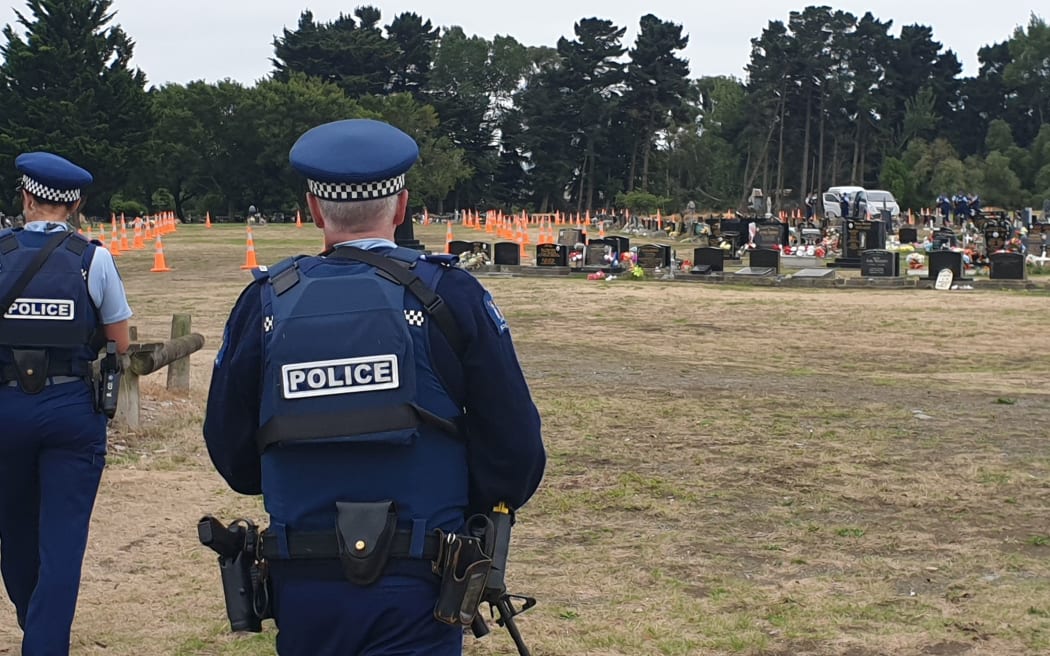 Armed police stand guard as Memorial Park Cemetery is prepared for the burial of victims of the Christchurch mass shooting.