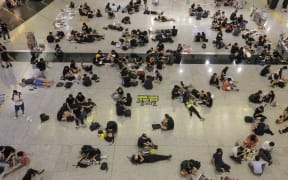 Protesters sit on the floor of the arrivals hall of Hong Kong's international airport.