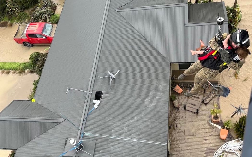 An NH90 helicopter and crew recover people from the rooftops of their homes in Esk Valley, Napier.