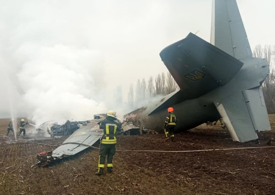 Emergency personnel work at the crash site of a Ukrainian military plane south of Kyiv on February 24, 2022.