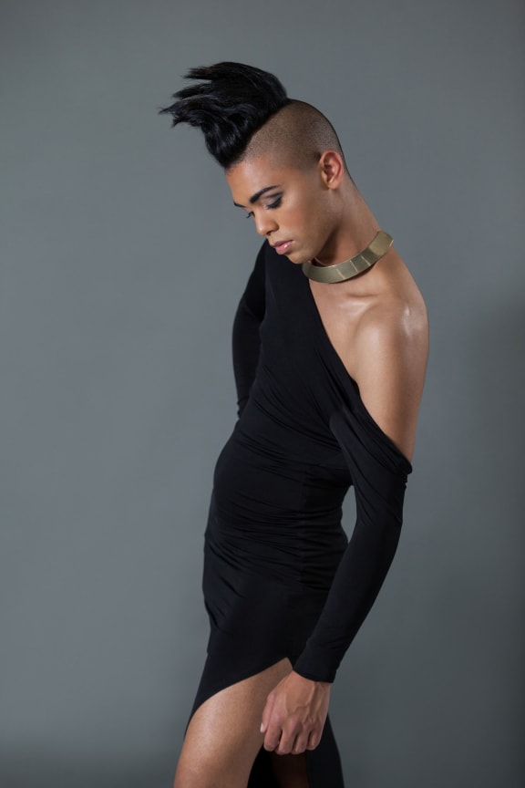 A photo of a young transgender woman a half shaved hairstyle and a black dress