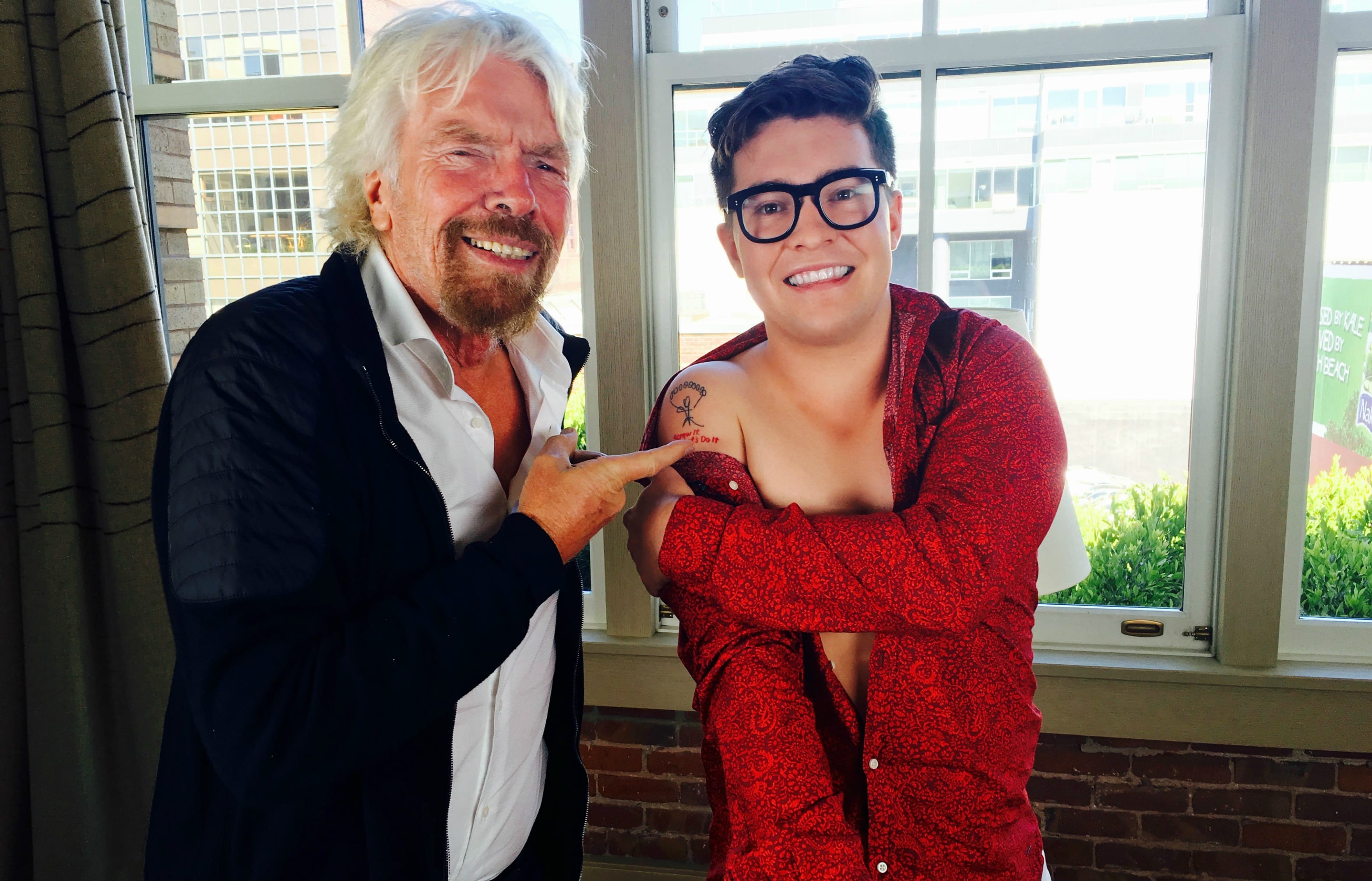 Jake Millar shows Richard Branson his tattoo. "The tattoo is a replica of a parachute my late father drew on my 10th birthday card. Underneath the parachute, it says 'Screw It, Let's Do It,' which is one of Richard's main quotes."