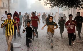 Palestinian children run as they flee from Israeli bombardment in Rafah in the southern Gaza Strip on November 6, 2023, amid continuing battles between Israel and the Palestinian militant group Hamas. (Photo by Mohammed ABED / AFP)