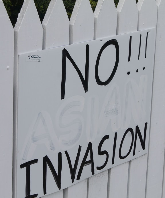 A sign on a fence in Whatuwhiwhi - "No Asian invasion." The word "asian" has been painted over.