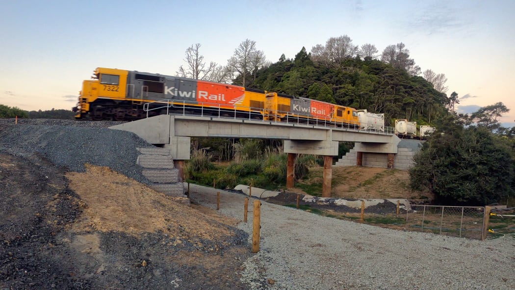 A freight train crosses the new Bridge 100, on Helleyer road, 15km from Helensville.  The new bridges have a concrete ballast tray deck which requires less maintenance than the old bridges, and can carry up to 25-tonne axle loads.